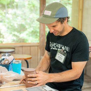 Travis Winters demonstrates a slab building technique in Touchstone's ceramic studio.